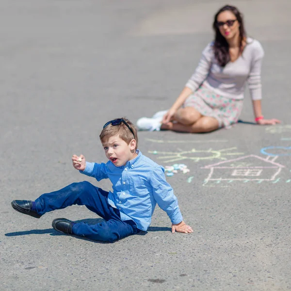 Mom and little son are painting with crayons on the road. — Stock Photo, Image