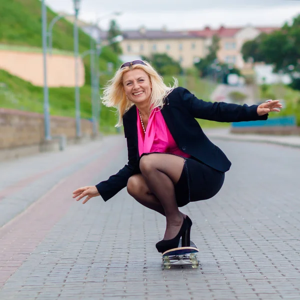 Senior obchodní žena baví na skateboardu venku — Stock fotografie