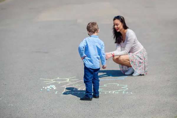 Mom and the little son draw with chalk on the road. — Stock Photo, Image
