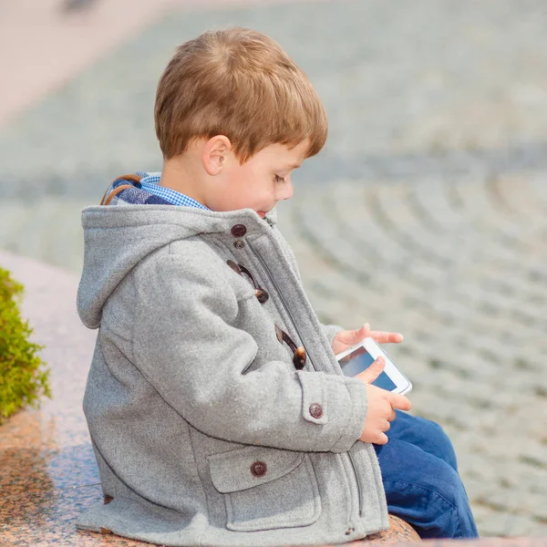 Petit garçon utilise une tablette à l'extérieur — Photo