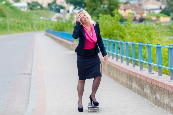 Senior zakenvrouw plezier op een skateboard buitenshuis — Stockfoto