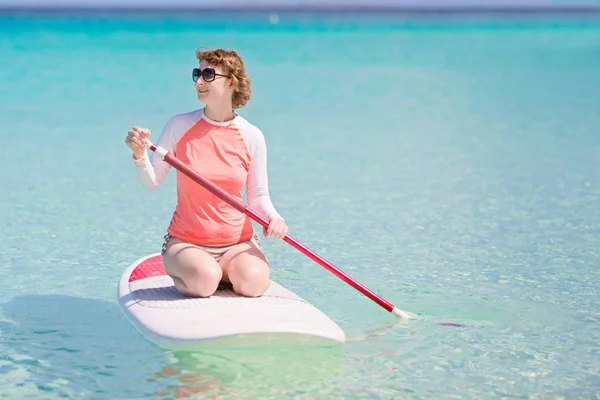 Mujer de pie paddleboarding — Foto de Stock