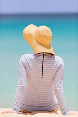 arkadan görünüşü kadın sunhat ve yaz plaj tatil, güneş koruma kavramı keyfi rashguard