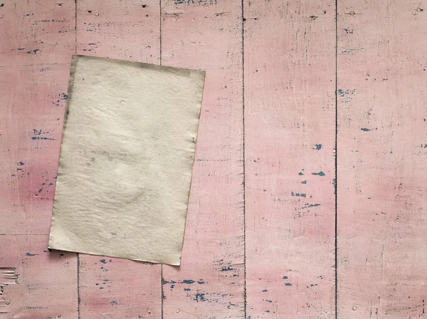 Бумага на розовой деревянной стене — стоковое фото