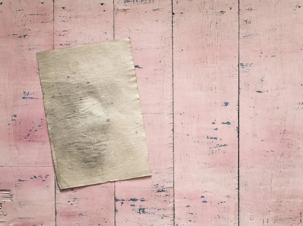 Бумага на розовой деревянной стене — стоковое фото