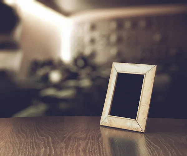 Old photo frame on wooden table — Stock Photo, Image