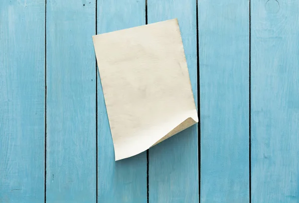 Oud papier op blauwe houten muur — Stockfoto