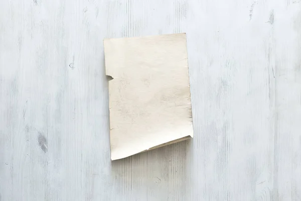 Старая бумага на белой стене — стоковое фото