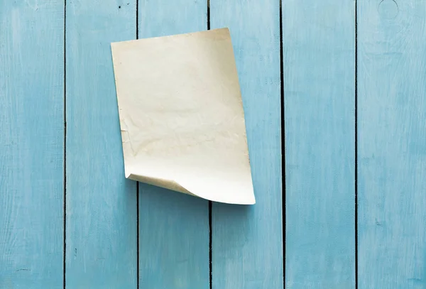 Старая бумага на голубой стене — стоковое фото