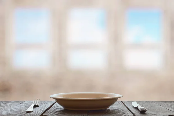 Plato vacío con tenedor y cuchillo sobre mesa de madera —  Fotos de Stock