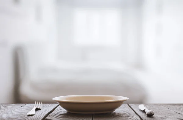 Plato vacío con tenedor y cuchillo sobre mesa de madera —  Fotos de Stock