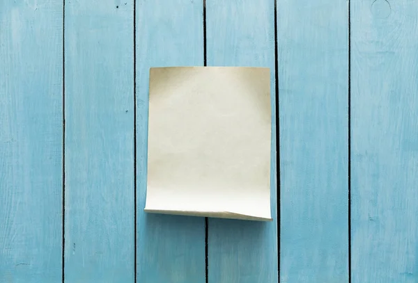 Blanco papier op houten muur — Stockfoto