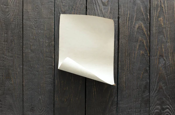 Чистый лист бумаги на деревянной стене — стоковое фото