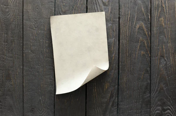 Чистый лист бумаги на деревянной стене — стоковое фото