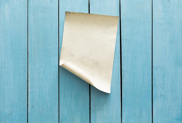 青い木製の壁の背景に古い紙 — ストック写真