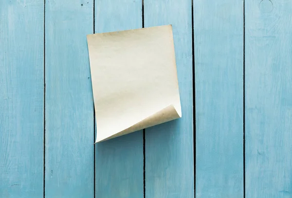 青い木製の壁の背景に古い紙 — ストック写真