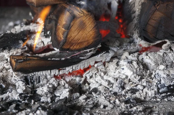De brandende brandhout op een brand — Stockfoto
