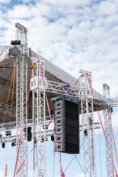 outdoor stage equipped with modern sound equipment against cloudy blue sky
