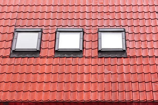 wet red tiled roof with skylights
