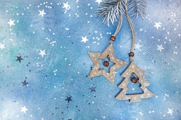 wooden christmas decorations on glittery blue background