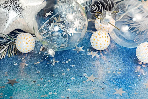 blue glitter background with sparkling confetti and different christmas tree decorations
