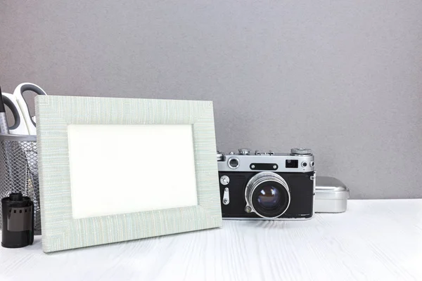old camera, roll films and stationary on grey background