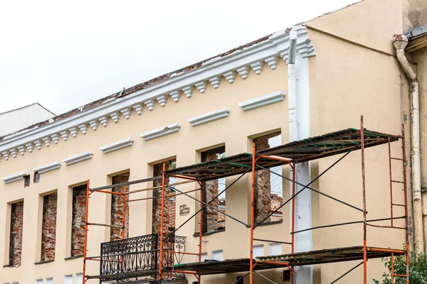renovation of old residential building with scaffolding near facade wall