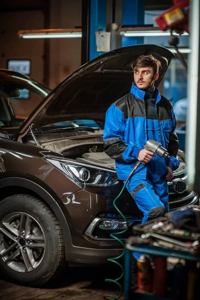 Jovem bonito mecânico de automóveis no trabalho — Fotografia de Stock