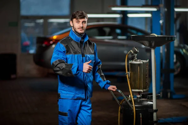 Joven mecánico de automóviles guapo en el trabajo — Foto de Stock