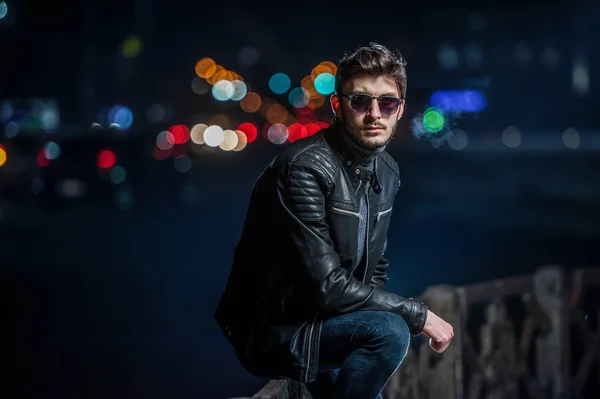 Stilvoller junger Mann in den Lichtern der Stadt bei Nacht — Stockfoto