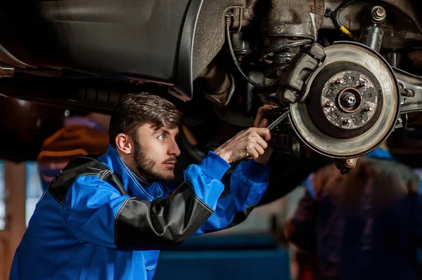 Junger hübscher Automechaniker bei der Arbeit — Stockfoto