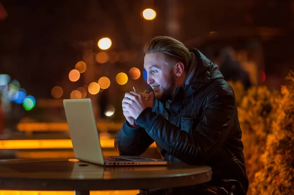 Schöner Kerl mit einem Computer in der Nacht — Stockfoto