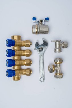 Beyaz zemin üzerinde bir İngiliz anahtarı ve metal bağlantı parçaları ile ayarla