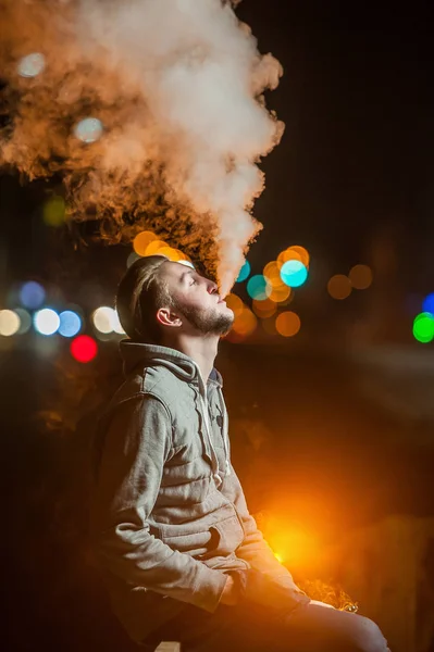 Pohledný mladý muž kouření elektronické cigarety — Stock fotografie