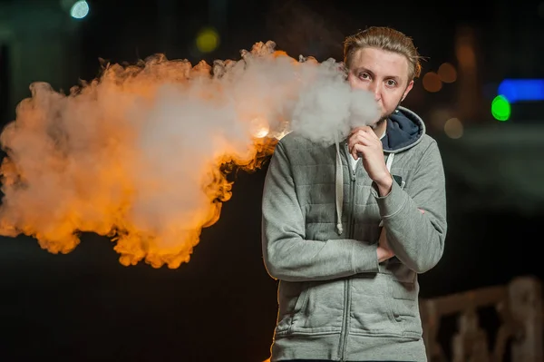 Handsome young man smoking electronic cigarette — Stock Photo, Image