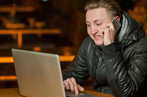 Knappe jonge man met een computer in de straat — Stockfoto