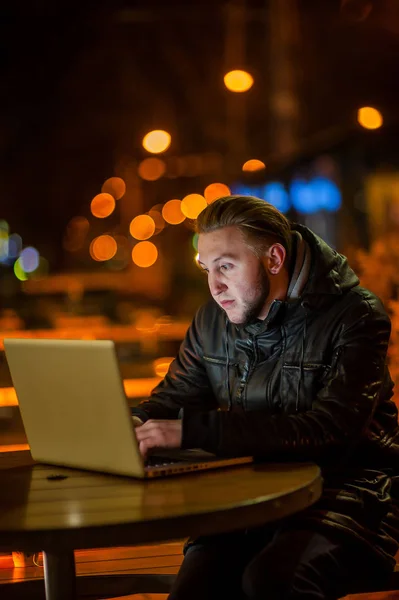 Stilig ung man med en dator på gatan — Stockfoto
