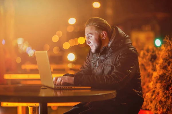 Knappe jonge man met een computer in de straat — Stockfoto