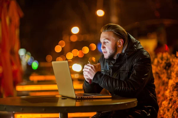 Knappe jonge man met een computer in de straat — Stockfoto