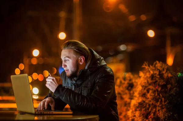 Stilig ung man med en dator på gatan — Stockfoto