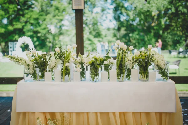 Prachtige bloemen in de vazen en decoraties op de bruiloft — Stockfoto