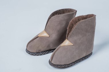 Beyaz zemin üzerinde bir ev yün için doğal terlik