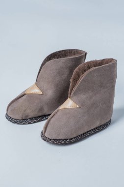 Beyaz zemin üzerinde bir ev yün için doğal terlik