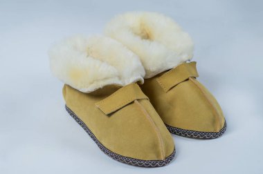 Beyaz zemin üzerinde bir ev yün için doğal terlik