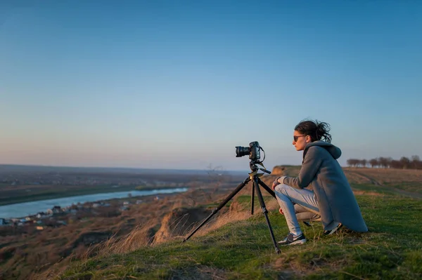 Um tripé com uma câmera dispara sobre a paisagem — Fotografia de Stock