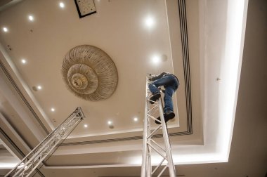 Adam metal bir merdiven üzerinde çalışıyor