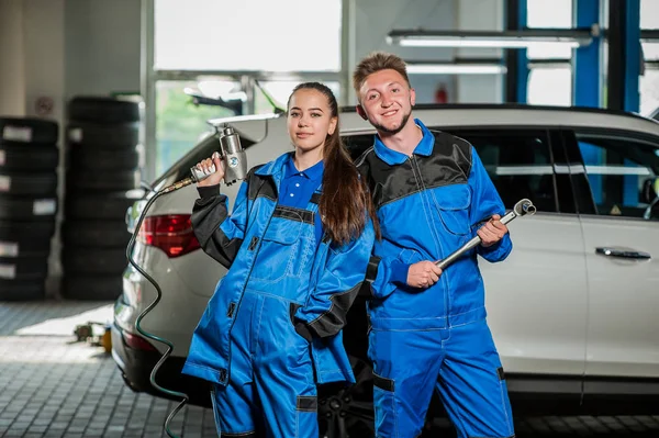 Hombre y mujer en la mecánica de automóviles — Foto de Stock