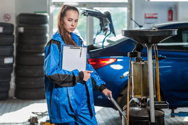 Junges schönes Mädchen bei einem Automechaniker bei der Arbeit — Stockfoto
