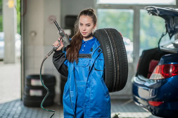 Joven hermosa chica en un mecánico de automóviles en el trabajo — Foto de Stock