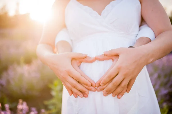 Belly of a pregnant woman and stones on it — Stock Photo, Image